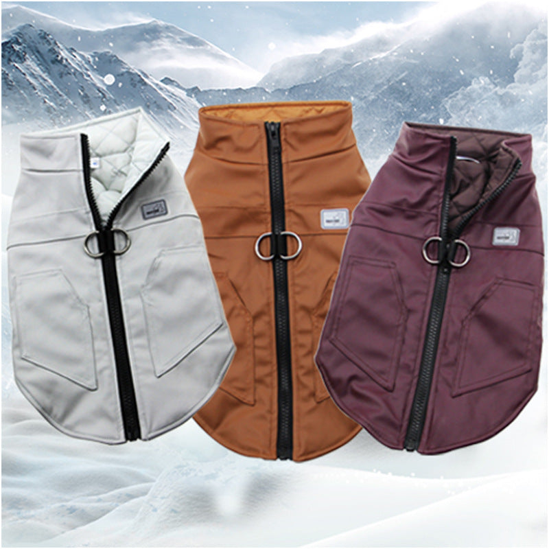 Three dog winter jackets in light gray, rust orange, and plum purple, displayed side-by-side against a snowy mountain background.