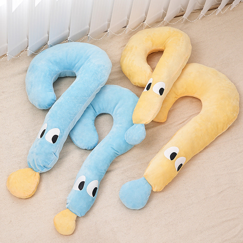 Two U-shaped neck pillows, one blue and one yellow, with cartoon face designs on a beige surface.